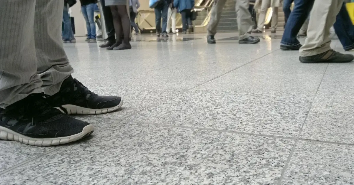 Foot traffic on tiled floor in busy public space.